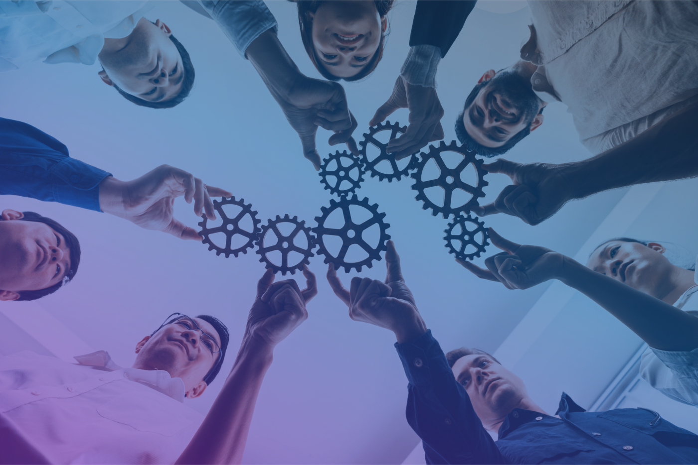 Team of diverse professionals holding interconnected gears, symbolizing collaboration, teamwork, and innovative problem-solving.